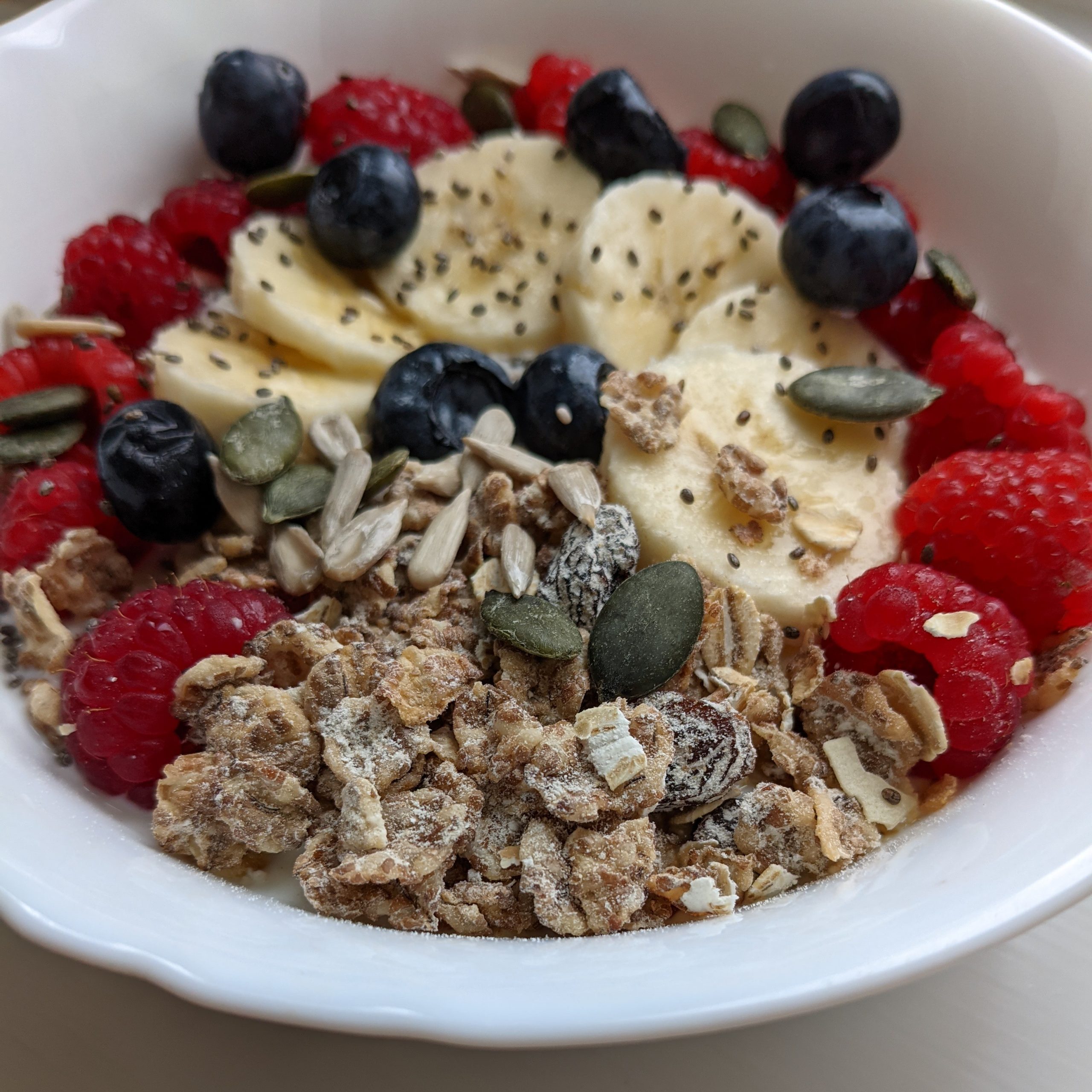 healthy-breakfast-recipe-ideas-vanilla-yoghurt-bowl-with-raspberries-banana-blueberries-muesli-granola-chia-seeds-pumpkin-seeds-sunflower-seeds-honey-oats