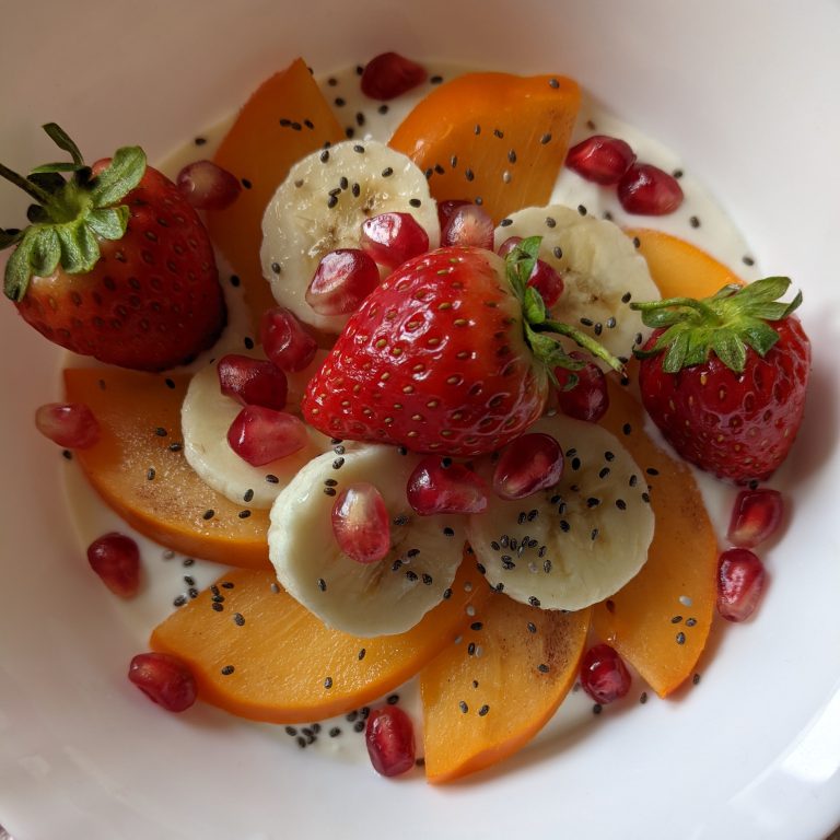 Healthy Vanilla Yoghurt Bowl with Persimmon, Banana, Strawberries, Pomegranate and Chia Seeds